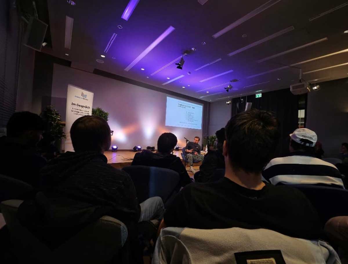 Teilnehmer lauschen einer Lesung mit Paul Ninus