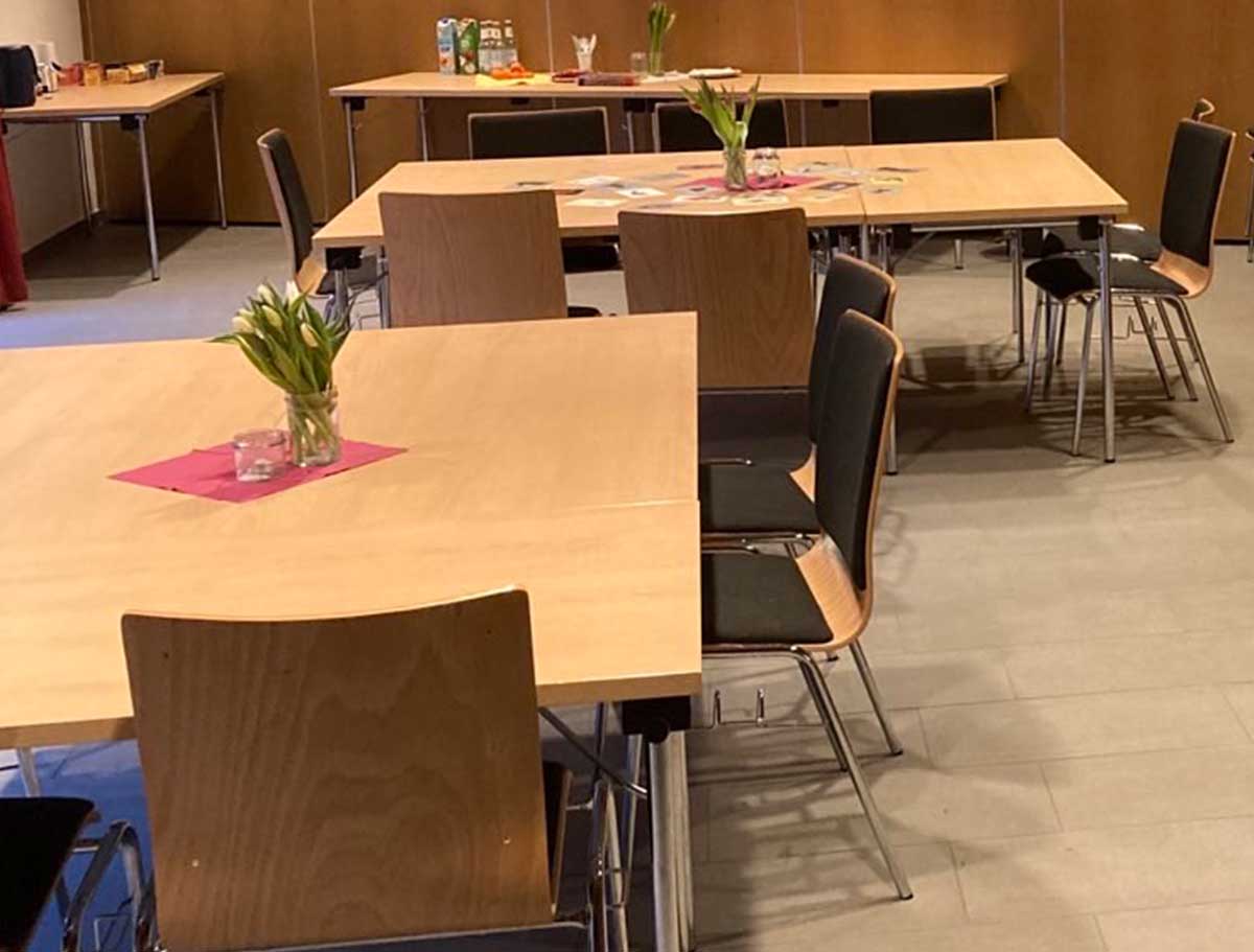 Ein einladender Vortragsraum mit Blumen auf den Tischen